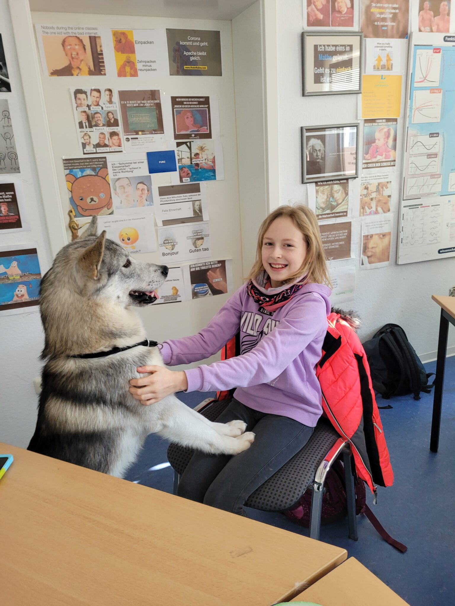 Schülerin sitzt entspannt neben Schulhund Loki